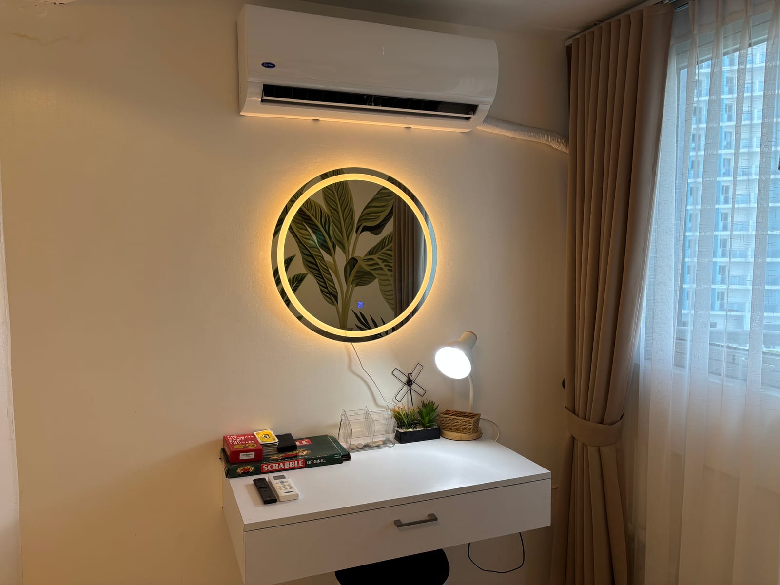 Vanity-workspace with LED-lit round mirror, board games, and city-view window